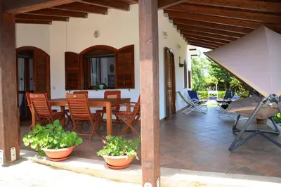 a patio with a table and chairs and a camera at Villa Fraginesi in Castellammare del Golfo