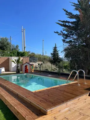 a pool with a wooden deck and a swimming pool with a wooden deck at Panorama del golfo in Balestrate