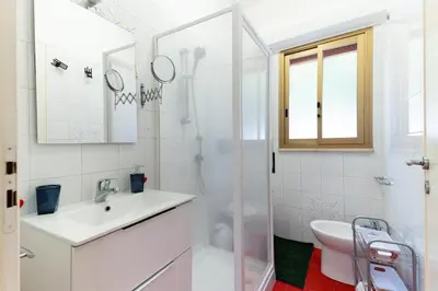 a white bathroom with a sink and a shower at Panorama del golfo in Balestrate