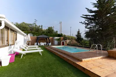 a backyard with a swimming pool and a wooden deck at Panorama del golfo in Balestrate