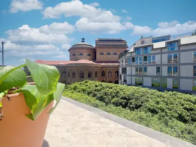 a plant in a pot in front of a building at Solemar Sicilia - Palazzo Massimo in Palermo