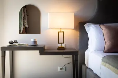 a lamp on a table next to a bed at Villa Masetta - Luxury Suites in Mondello
