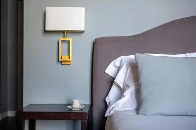 a bed with a lamp next to a side table with a bed sidx sidx sidx at Villa Masetta - Luxury Suites in Mondello
