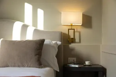 a bedroom with a bed and a lamp on a table at Villa Masetta - Luxury Suites in Mondello