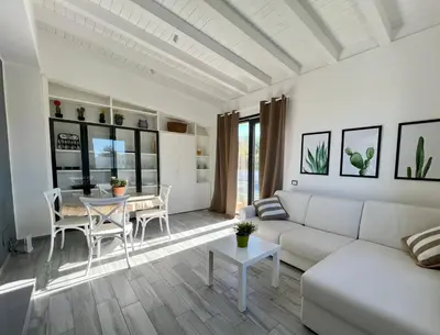 a living room with a white couch and a table at Rosalia Homestay - Ponente Apartment in Cinisi