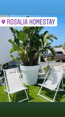 a white chair sitting on top of a wooden deck at Rosalia Homestay - Ponente Apartment in Cinisi