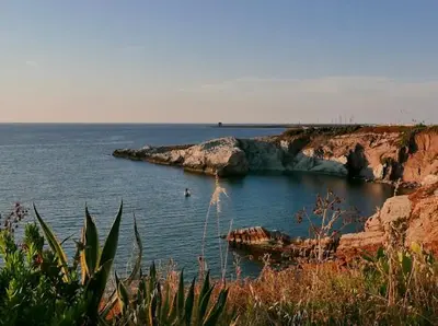 a large body of water with rocks in the water at Rosalia Homestay - Ponente Apartment in Cinisi