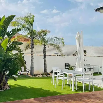 a patio with a table and chairs and palm trees at Rosalia Homestay - Levante Apartment in Cinisi