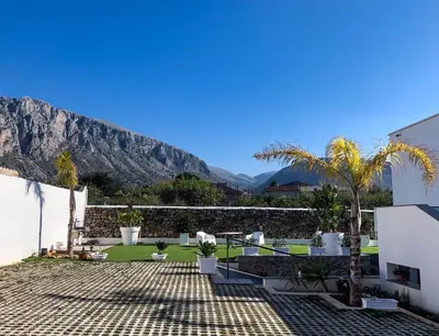 a balcony with two toilets and a rock wall at Rosalia Homestay - Levante Apartment in Cinisi