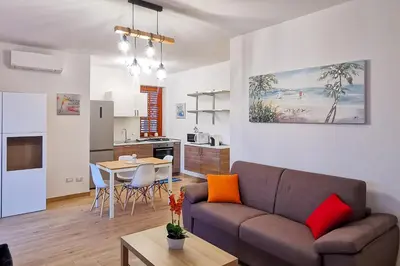 a living room and kitchen with a couch and a table at Elite Residence Mondello in Mondello