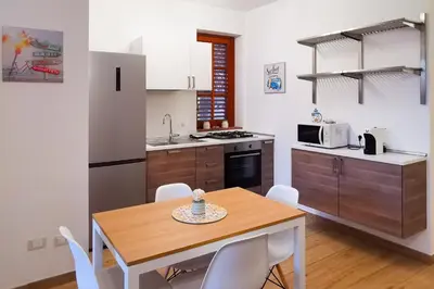 a kitchen with a table and chairs in a room at Elite Residence Mondello in Mondello