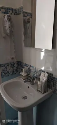 a bathroom with a sink and a mirror at B&B AMISTANZA in Palermo