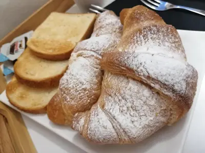 a plate of bread with powdered sugar on it at B&B AMISTANZA in Palermo