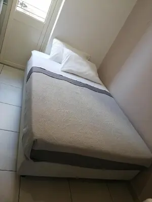 a bed in a small room with a window at B&B AMISTANZA in Palermo
