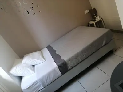 a bed with white sheets and pillows in a room at B&B AMISTANZA in Palermo