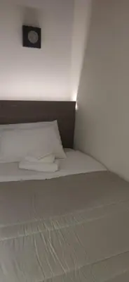 a white bed with a clock on top of it at B&B AMISTANZA in Palermo