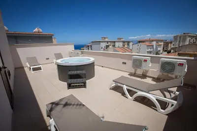 a balcony with a hot tub and a grill at Casa Vacanza Barone in Castellammare del Golfo