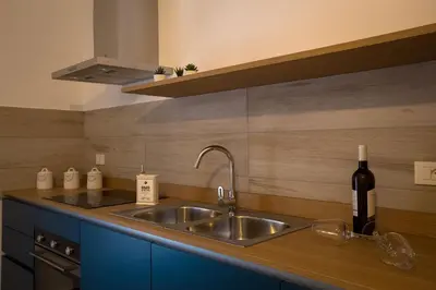 a kitchen with a sink and a bottle of wine at Casa Vacanza Barone in Castellammare del Golfo