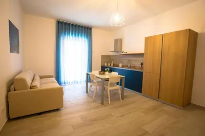 a living room with a table and a couch and a kitchen at Casa Vacanza Barone in Castellammare del Golfo