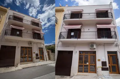 a white building with a balcony on the side at Casa Vacanza Barone in Castellammare del Golfo