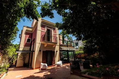 a building with a balcony and two white chairs at LuminHouse Mondello Valdesi in Palermo