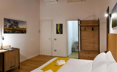 a bedroom with a white bed and a bathroom at Ballarooms B&B Palermo Centro in Palermo