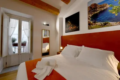 a bedroom with a large white bed and a window at Ballarooms B&B Palermo Centro in Palermo