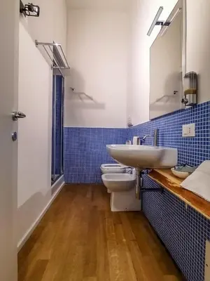 a bathroom with a sink and a toilet and a mirror at Ballarooms B&B Palermo Centro in Palermo