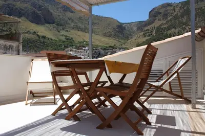a wooden table and two chairs on a balcony at Voltamare in Castellammare del Golfo