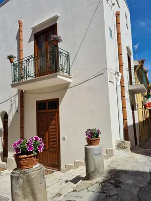 a building with two pots of flowers in front of it at Voltamare in Castellammare del Golfo