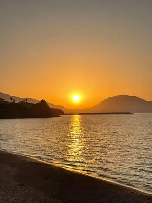 a sunset on the beach with the sun setting at LA FINESTRA SUL MARE in Trappeto