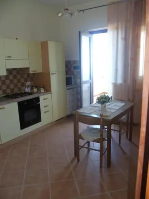 a kitchen with a table and a small table and a table and a table at LA FINESTRA SUL MARE in Trappeto