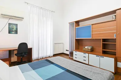a bedroom with a bed and a desk and a television at Vittorio Emanuele & Via Roma Colorful Apartment in Palermo