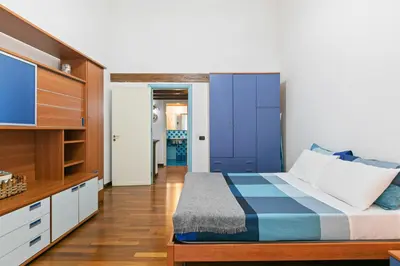 a bedroom with a blue and white bed and a tv at Vittorio Emanuele & Via Roma Colorful Apartment in Palermo