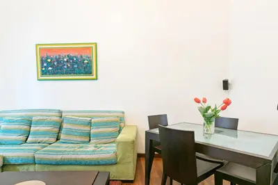 a living room with a couch and a table at Vittorio Emanuele & Via Roma Colorful Apartment in Palermo