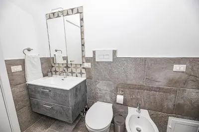 a bathroom with a sink and a toilet and a mirror at Casa Raffadali, in centro storico a Palermo in Palermo