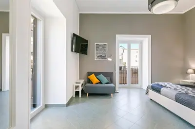 a bedroom with a bed and a couch at GuestHost - Stylish Flat Maqueda in Palermo