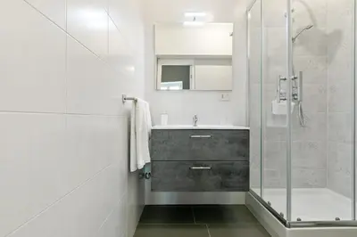 a bathroom with a sink and a glass shower at GuestHost - Stylish Flat Maqueda in Palermo