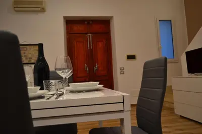 a dining room with a white table with wine glasses at Appartamento del Golfo in Castellammare del Golfo