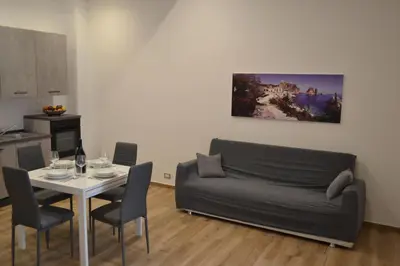 a living room with a couch and a table with chairs at Appartamento del Golfo in Castellammare del Golfo