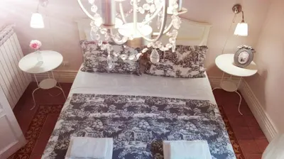 a bedroom with a large bed with a chandelier at B&B Abbacò in Palermo