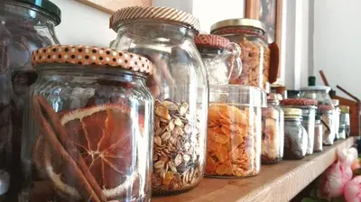a row of jars of nuts and seeds on a shelf at B&B Abbacò in Palermo