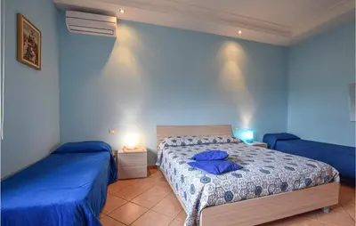 a bedroom with two beds with blue walls at Stunning Home In Castellammare Del G in Castellammare del Golfo