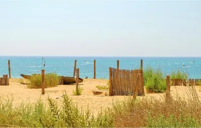a wooden fence in the sand on the beach at Cozy Apartment In Castellammare Dg in Castellammare del Golfo