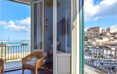 a balcony with a chair and a view of the ocean at Cozy Apartment In Castellammare Dg in Castellammare del Golfo