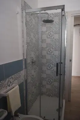 a shower with a glass door in a bathroom at Appartamenti AcquaChiara in San Vito lo Capo