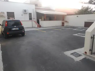 a car parked in a parking lot next to a building at Appartamenti AcquaChiara in San Vito lo Capo