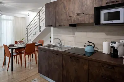 a kitchen with a sink and a table with chairs at Residence Salinelle Beach Villa Salina 5 in Lascari