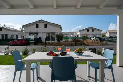 a white table and chairs on a patio at Residence Salinelle Beach Villa Salina 5 in Lascari
