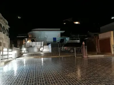 a person standing on a tiled sidewalk at night at Apartment in Alcamo near the Beach in Alcamo Marina